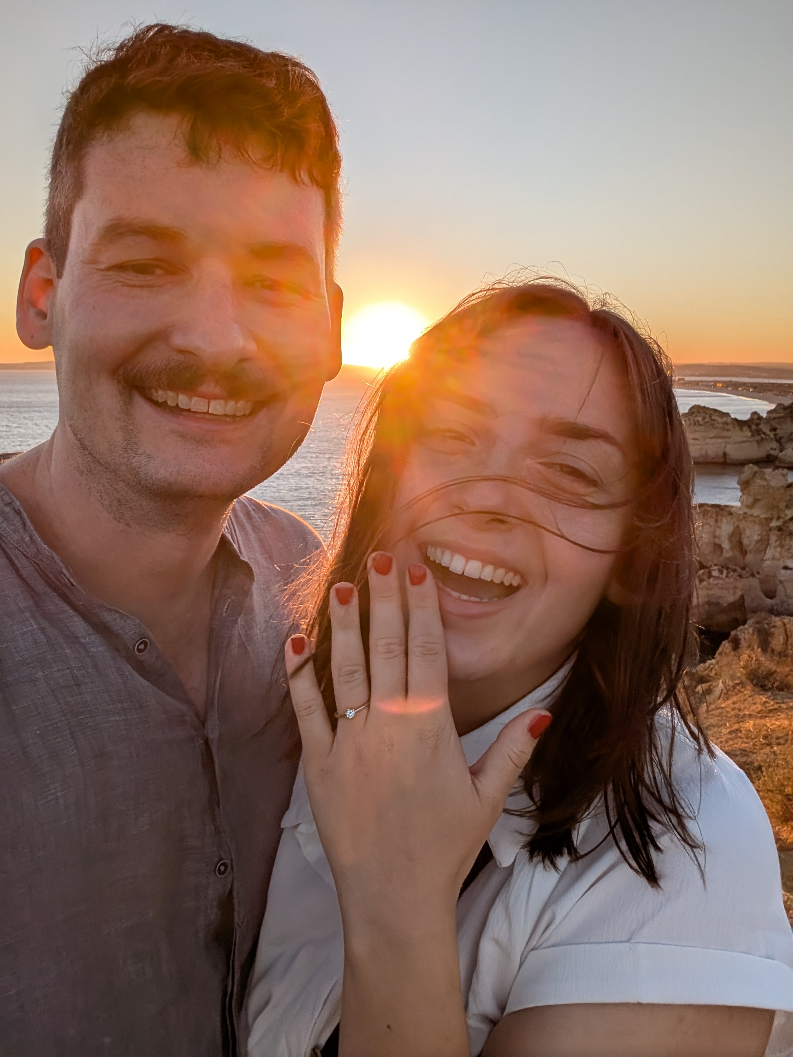 Julia & Christoph schauen aus wie zwei Models bei der Verlobung an der portugiesischen Küste während dem Sonnenuntergang